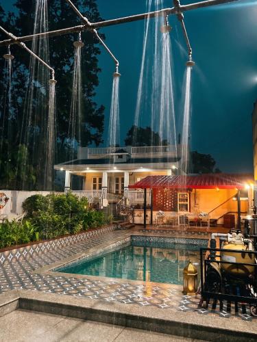 a pool in front of a house at night at Kudrat Villa with Private Pool in Dehradun