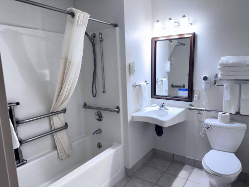 a bathroom with a toilet and a sink and a bath tub at Quality Inn Spearfish I-90 in Spearfish