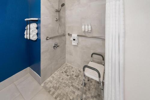 a shower with a chair in a bathroom at La Quinta by Wyndham Ruidoso Downs in Ruidoso Downs
