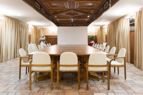 a conference room with a wooden table and chairs at Hotel Il Cervo, SPA & Wellness, Bike Hotel in Tarvisio