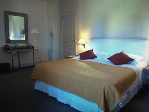 a hotel room with a large bed and a mirror at La Maison Saint Jean in Boulbon
