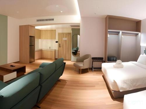 a hotel room with a bed and a couch at J HOTEL in Kampong Kiulap