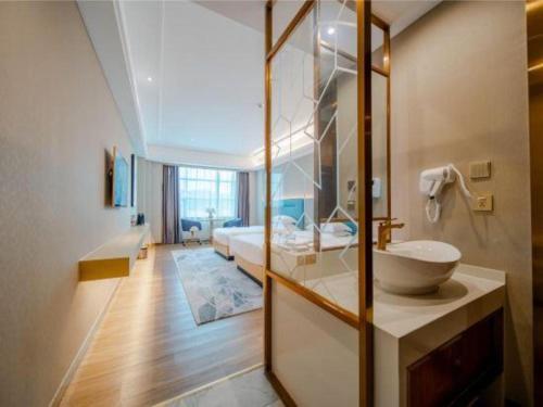 a bathroom with a sink and a bed in a room at Cheermay Hotels in Dongguan