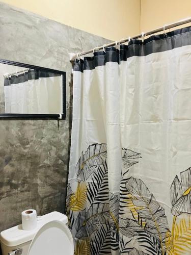 a bathroom with a toilet and a shower curtain at Otorongo Guesthouse in Iquitos