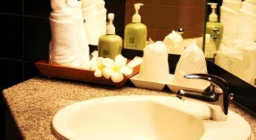 a bathroom counter with a sink and a mirror at Gerard Habitat Hotel in Chiang Mai