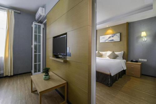 a hotel room with a bed and a tv at H Life Hotel in Shenzhen