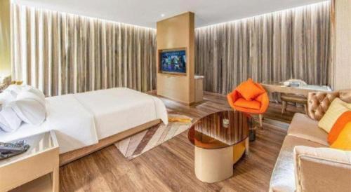 a hotel room with a bed and a couch at Tomeet Hotel in Meizhou