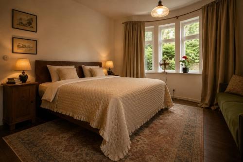 a bedroom with a bed and a window and a couch at HAUS 1926 Łagów Boutique Villa in Łagów