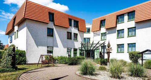 a large white building with a red roof at Best Western Spreewald in Lübbenau