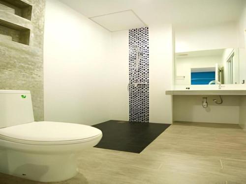 a bathroom with a white toilet and a shower at Thalassa Hotel in Ko Tao