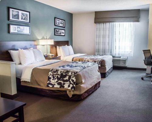 a hotel room with two beds and a window at Sleep Inn & Suites Monticello in Charlottesville