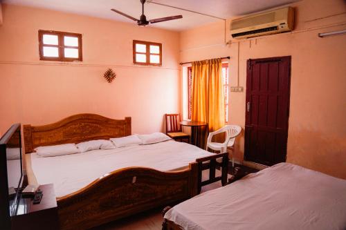 a bedroom with two beds and a window at JS Homestay in Nāgercoil