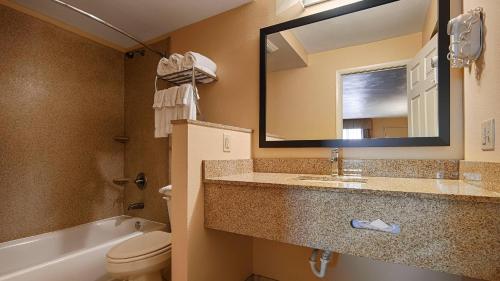 a bathroom with a sink and a toilet and a mirror at Quality Inn & Suites Williamsport in Williamsport