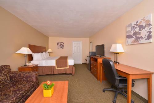 a hotel room with a bed and a desk at Quality Inn & Suites Williamsport in Williamsport