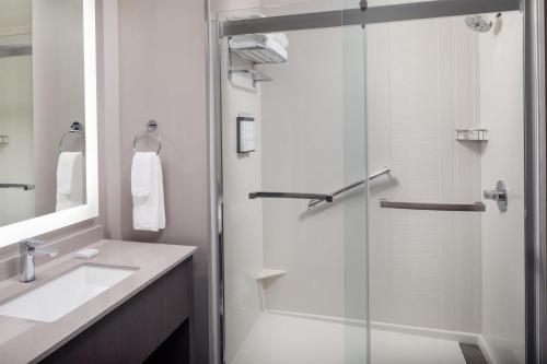 a bathroom with a glass shower and a sink at Hyatt House Destin in Destin
