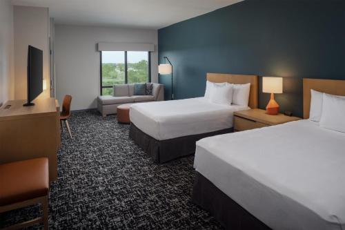 a hotel room with two beds and a couch at Hyatt House Destin in Destin