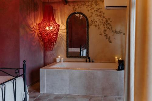 a bathroom with a tub with a mirror and candles at KISLOV Vineyard Boutique Hotel in Hagimus