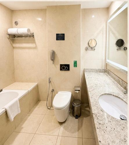 a bathroom with a toilet and a sink at Jacob's Garden Hotel in Dubai