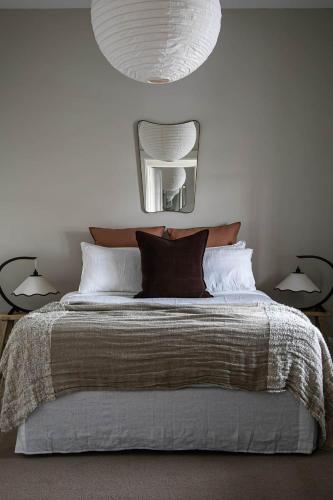 a bedroom with a bed with a mirror and two lamps at Little Elizabeth in West Hobart