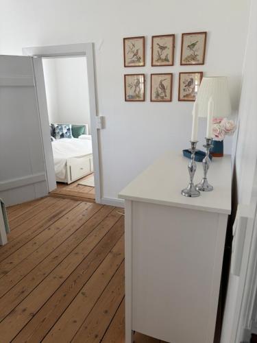 a room with a table with a lamp and a mirror at The South Wing at Højbygård in Rødby