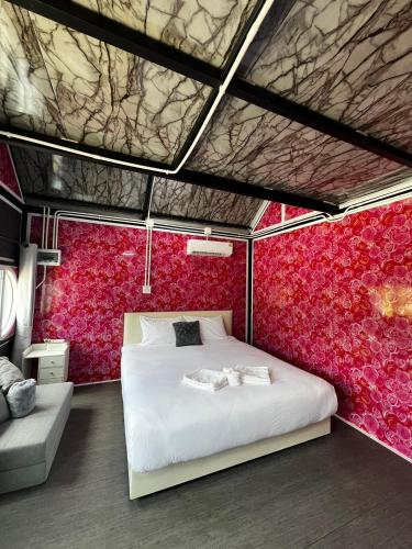 a bedroom with a white bed and a red wall at Siriwan boutique hotel in Ban Met Nang Chi