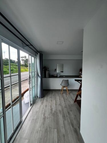 a living room with a large window and a table at Siriwan boutique hotel in Ban Met Nang Chi