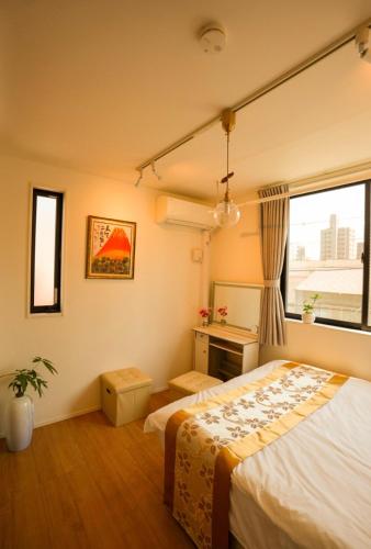 a bedroom with a bed and a window at 和モダン福 名古屋駅徒歩8分 最大10名 一軒家貸切 寝室3 in Minami-sotoborichō