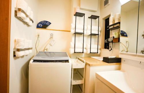 a small kitchen with a stove and a sink at 和モダン福 名古屋駅徒歩8分 最大10名 一軒家貸切 寝室3 in Minami-sotoborichō