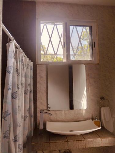 a bathroom with a large mirror and a sink at Casa Imox in Bacalar