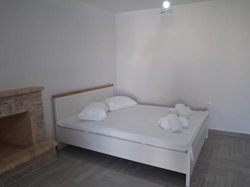 a bedroom with a bed with white sheets and pillows at Makri Guest House in Livanates