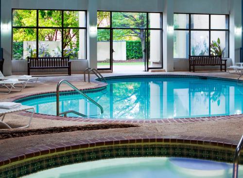 a large swimming pool in a hotel with windows at Radisson Hotel Hauppauge-Long Island in Hauppauge