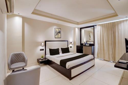 a hotel room with a bed and a chair at Super Townhouse Oak Udyog Vihar in Gurgaon