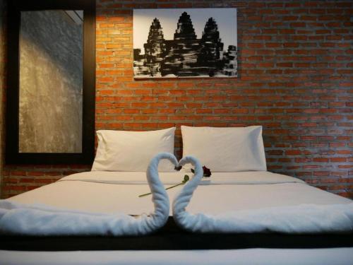 two swans are forming a heart on two beds at 41Studio in Nakhon Phanom