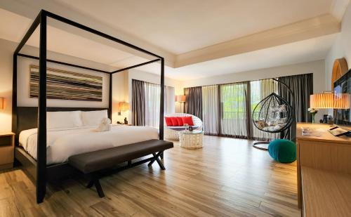 a bedroom with a large bed and a desk at Sand & Sandals Desaru Beach Resort & Spa in Desaru