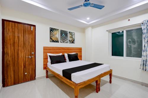a bedroom with a bed and a wooden door at Hotel O Madurawada Formerly IT Sez in Visakhapatnam