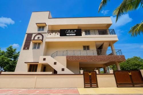 a tall white building with a sign on it at Collection O Anbu Nagar Coimbatore in Coimbatore