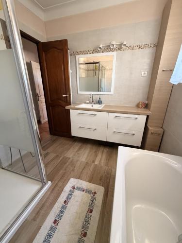 a bathroom with a tub and a sink and a mirror at Maison des pruniers in Furiani