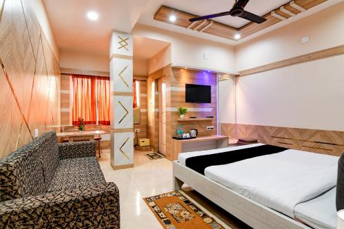 a bedroom with a bed and a couch and a tv at Hotel Shree Krishna in Keonjhargarh