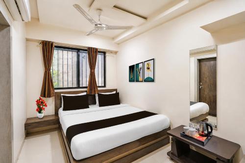 a bedroom with a large bed and a table at Hotel O Sabarmati Ashram Ahmedabad Formerly Red Apple in Ahmedabad
