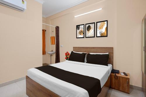 a bedroom with a large bed with three pictures on the wall at Super Collection O Yeshvantpur Railway Junction Formerly Sasthi Inn in Bangalore