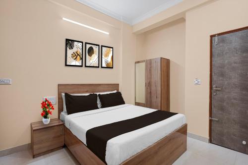 a bedroom with a large bed and a door at Super Collection O Yeshvantpur Railway Junction Formerly Sasthi Inn in Bangalore