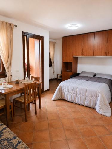 a bedroom with a bed and a table and a dining room at La Splaza Home in Pian Camuno