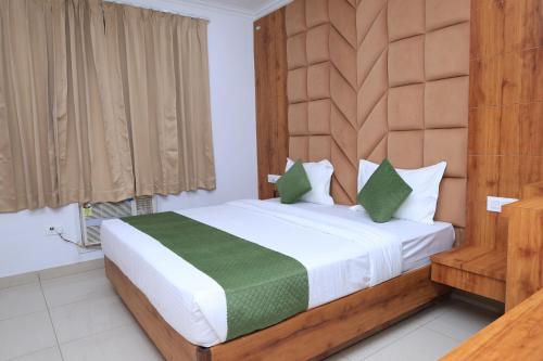 a bedroom with a large bed with a wooden headboard at Hotel New JMK in Katra