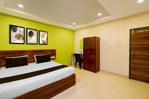 a bedroom with a bed with a green wall at Super Hotel O AMR Planet Mall Hyderabad Formerly R Square in Maula Ali