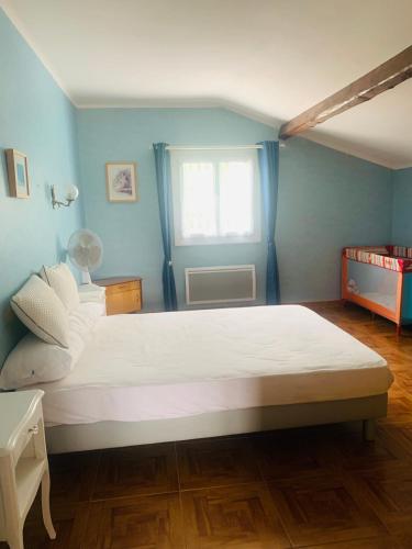 a bedroom with a large white bed with a window at La Bienvenue in Tourtrol