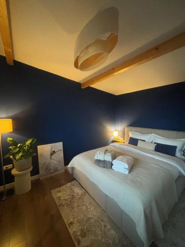 a bedroom with a large bed with blue walls at Casa Tamy Bran in Sohodol