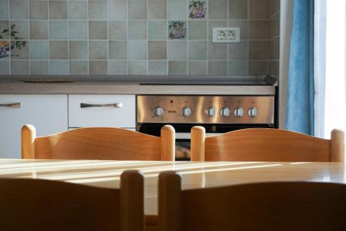 a kitchen with a stove and a table with two chairs at Apartments Kravanja in Bovec