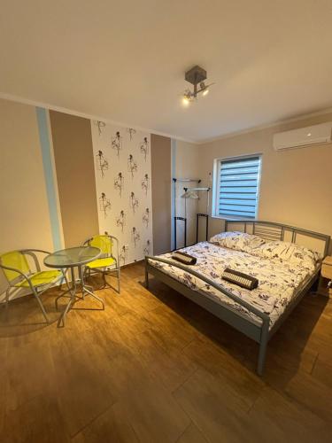 a bedroom with a bed and a table and chairs at Babzsi Nyaraló in Vonyarcvashegy