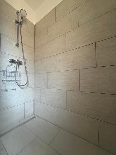 a bathroom with a shower with a tile wall at Babzsi Nyaraló in Vonyarcvashegy