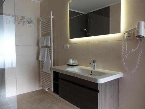 bagno con lavandino, specchio e doccia di Seminarhotel Daniels a Gols